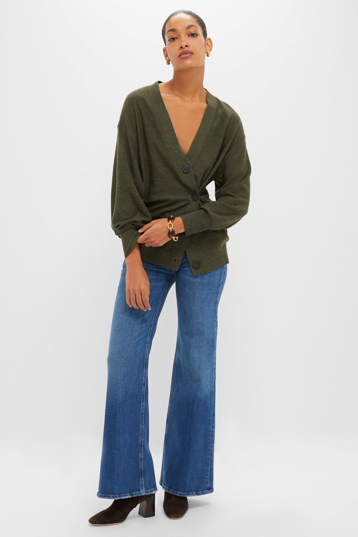 Woman models Olive Drippy Tissue Cardigan: classic V-neck wrap, side button cinch, high-end look; paired with flared jeans, suede boots, gold hoops, embodying effortless, fun style.