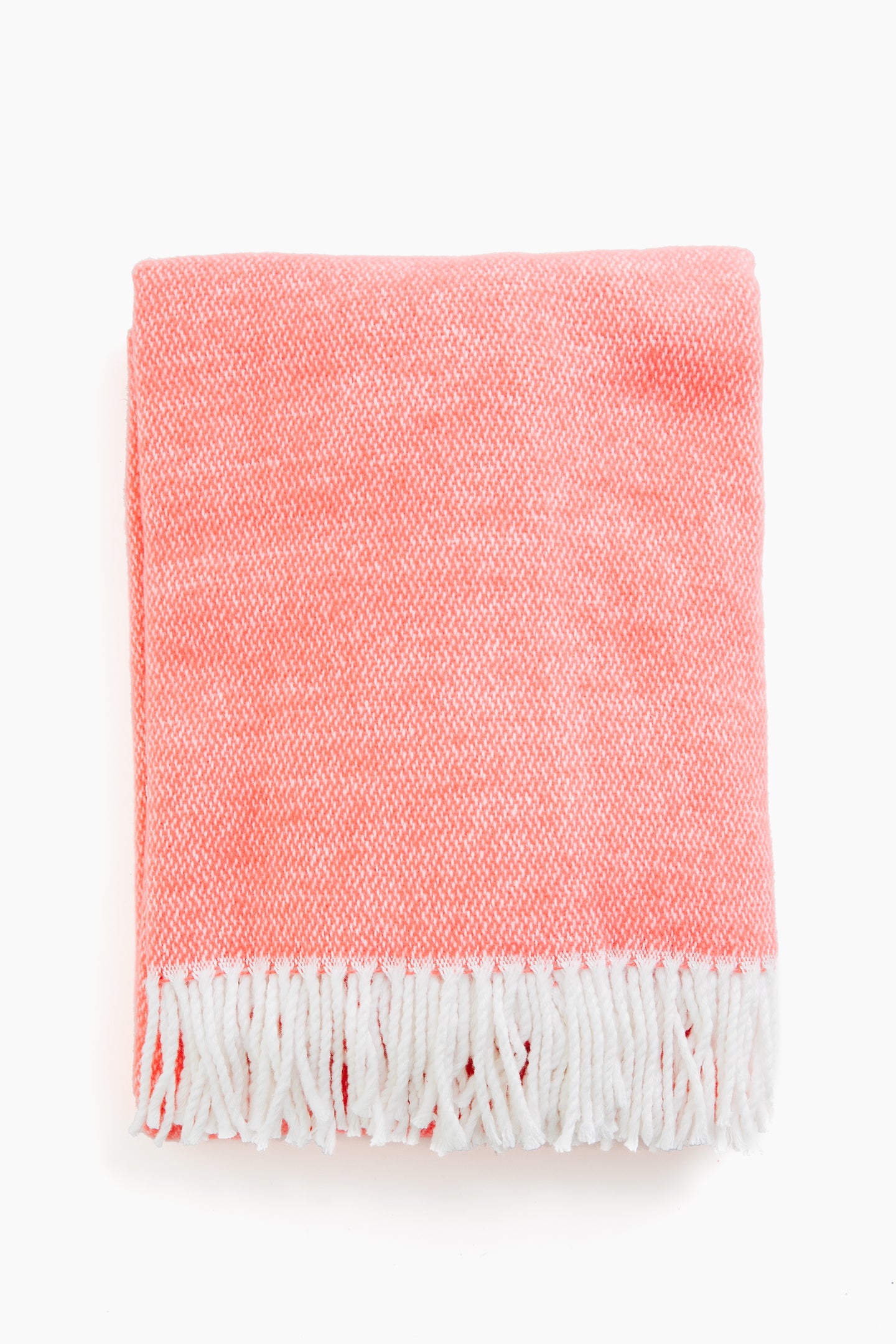 A folded Matouk coral throw made from brushed cotton, featuring white fringe trim along the edges.