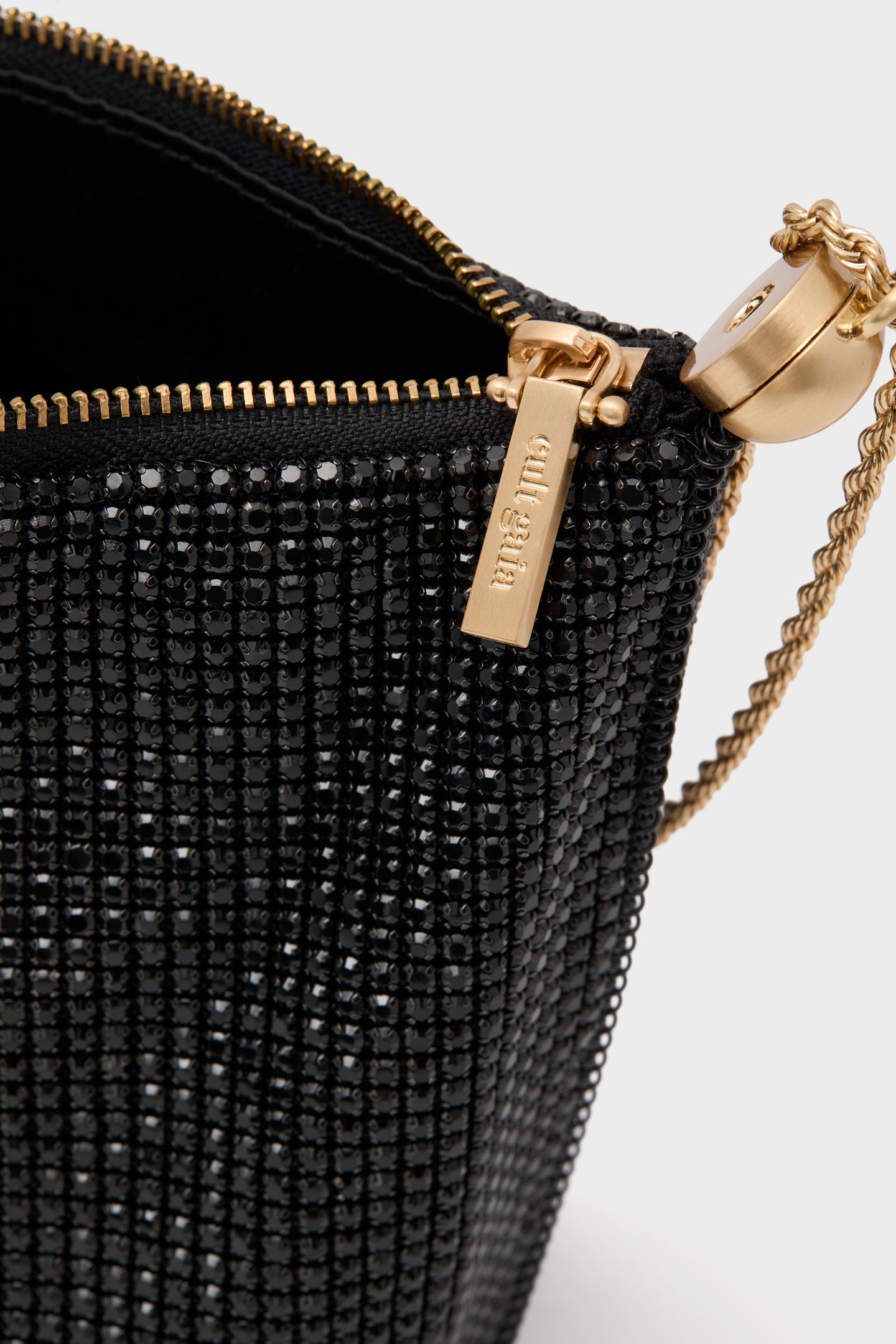 Cult Gaia Black Rue Wristlet, adorned with black beads and gold detailing, exudes classic elegance and effortless glamour, perfect for high-end evening events.