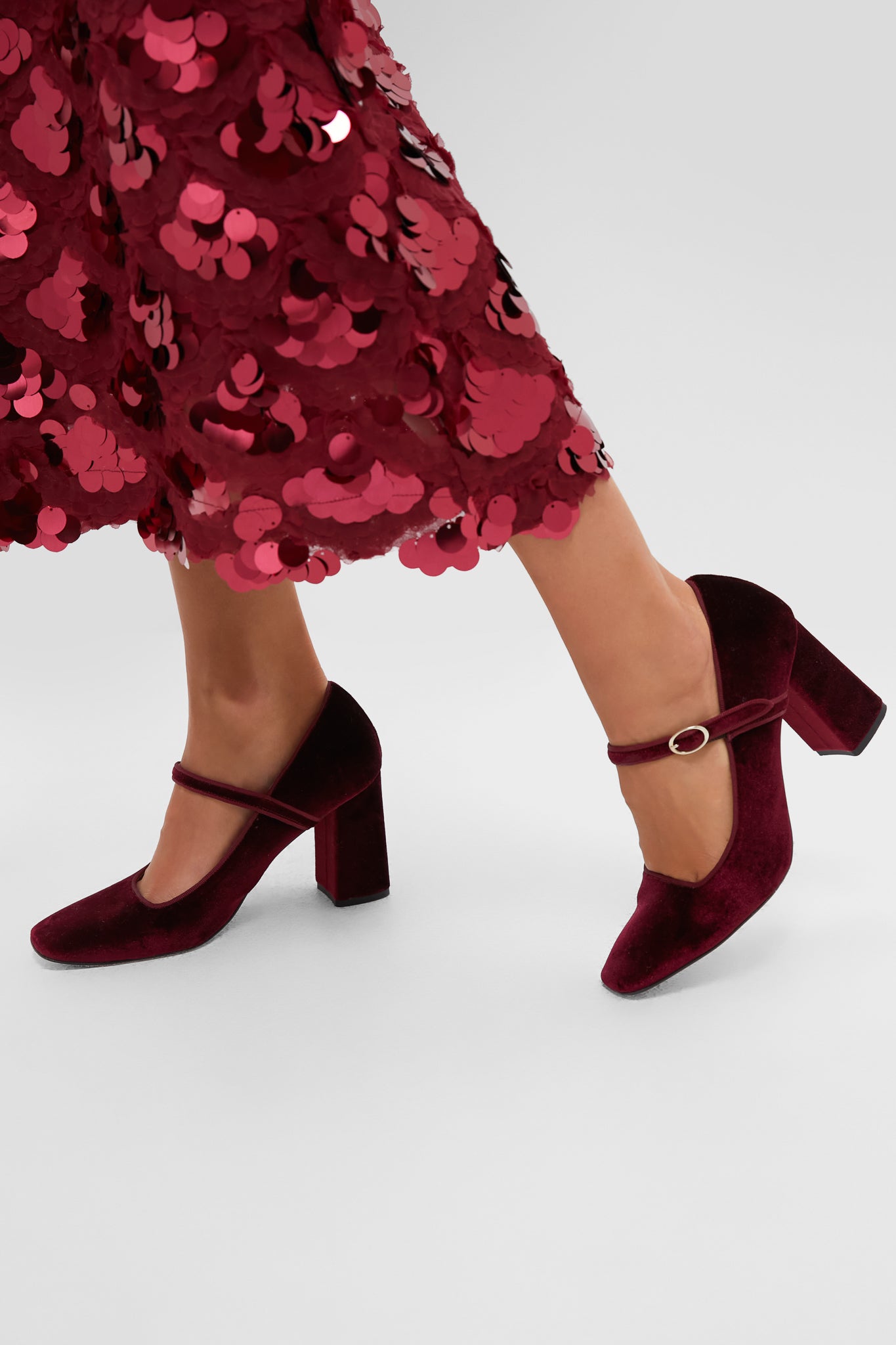 Oxblood Velvet Julia Heels: Classic Mary-Jane pumps with a block heel and gold-accented strap, embodying effortless elegance and fun sophistication. Perfect for high-end, chic ensembles.