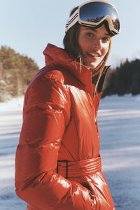 Young woman in snowy landscape wearing the Red Candice Ski Parka with goggles, showcasing a classic, high-end, and effortlessly fun look, perfect for adventurous slopes.