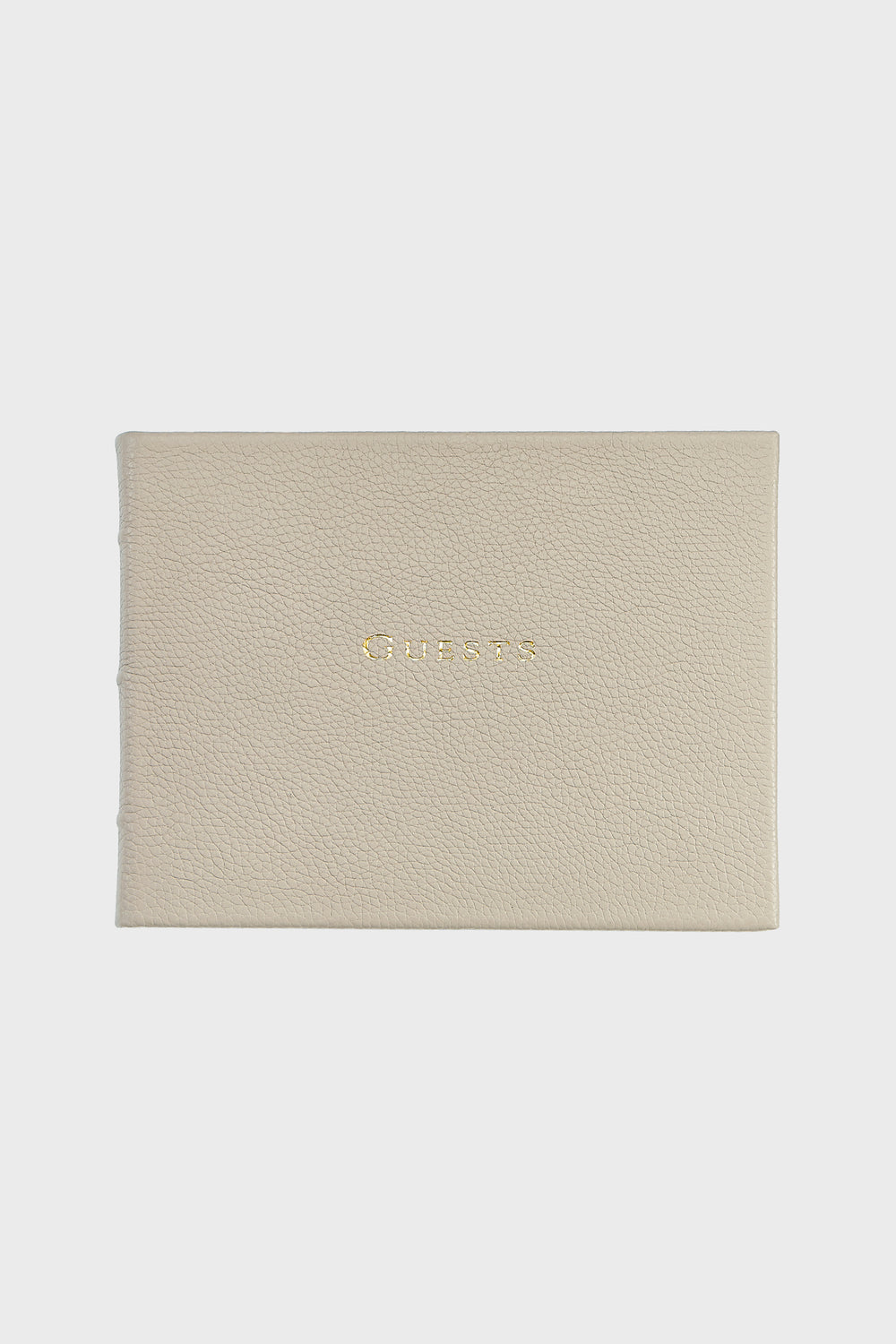 The Graphic Image beige leather guest book features "Guests" embossed in gold on the cover, highlighting their elegant handmade leather craftsmanship.
