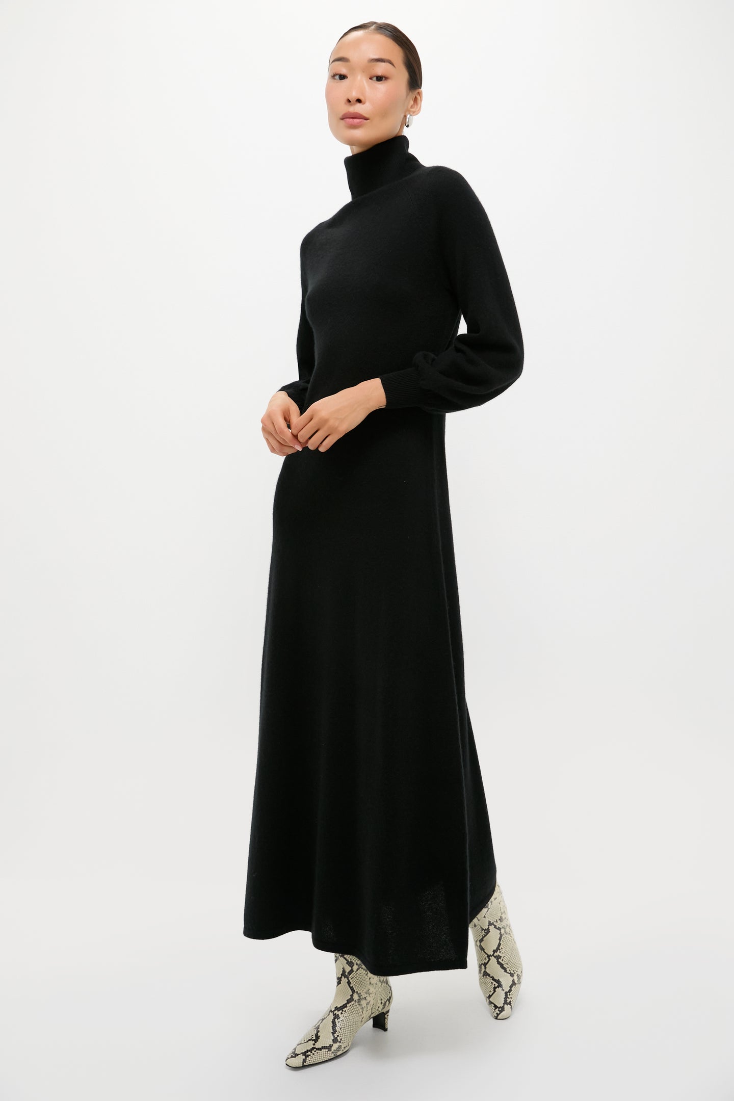 Classic Black Cashmere Turtleneck Maxi Dress with blouson sleeves and A-line silhouette, styled effortlessly with light snakeskin ankle boots, embodying a high-end, fun, and versatile look.