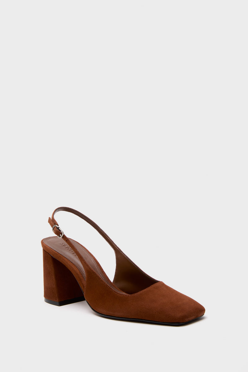 The Schutz slingback block heel shoe features brown suede, a closed square toe, and an adjustable strap, displayed on a plain light gray surface.
