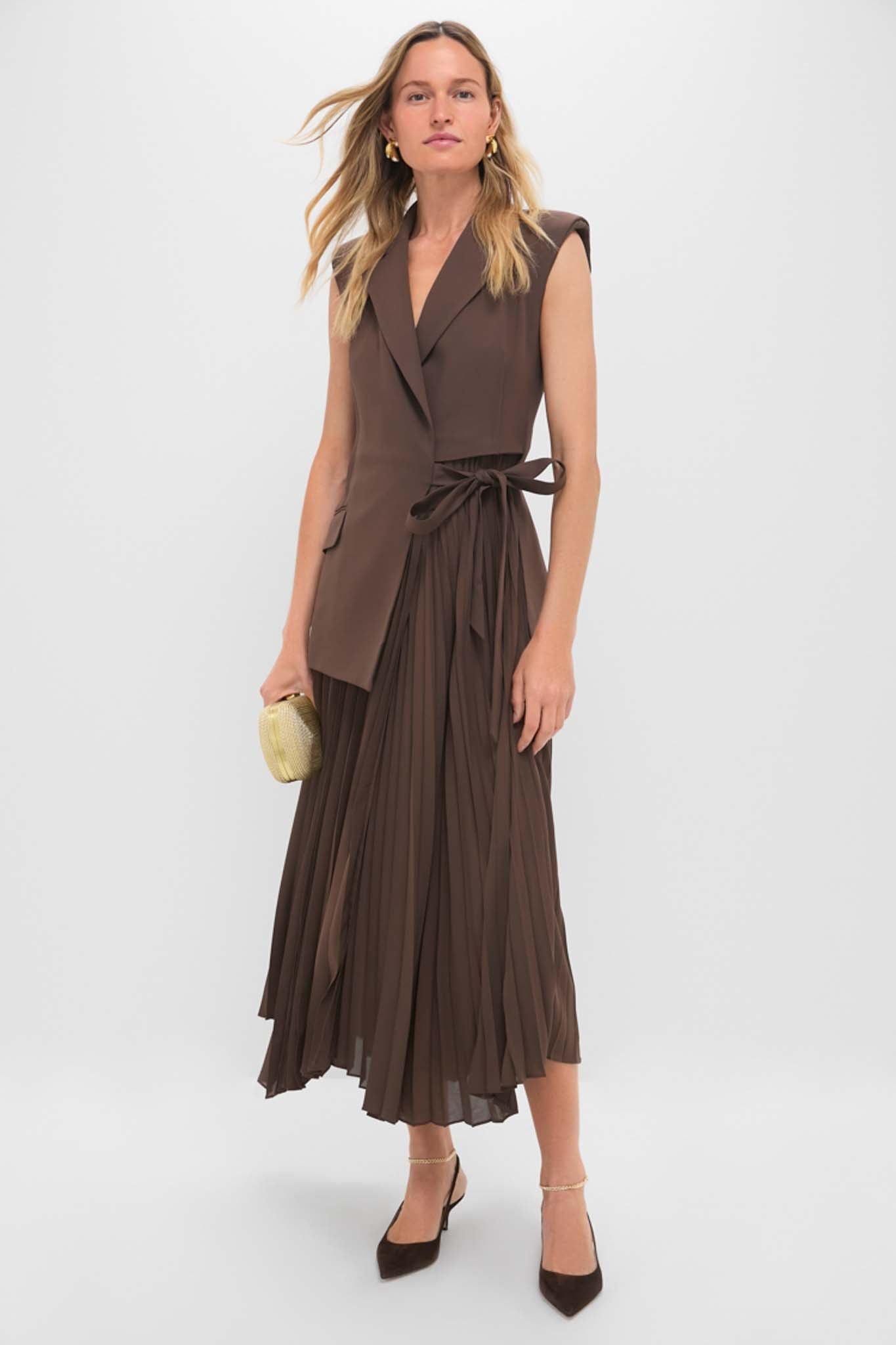 Model showcasing classic Dark Brown Felicia Slingback Heels with pointed toes and ankle straps, styled with a wrap top and pleated skirt for an effortless, high-end look.
