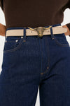 Person wearing classic dark jeans and a light-tan belt featuring a high-end, gold-tone longhorn buckle. The Espresso and Chantilly Suede Belt exudes effortless style.