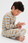 Child in classic Tigers Kids Bamboo Pj Set, effortlessly examining fingers. Light blue, breathable bamboo fabric, perfect for fun, cozy moments. High-end comfort meets playful design.