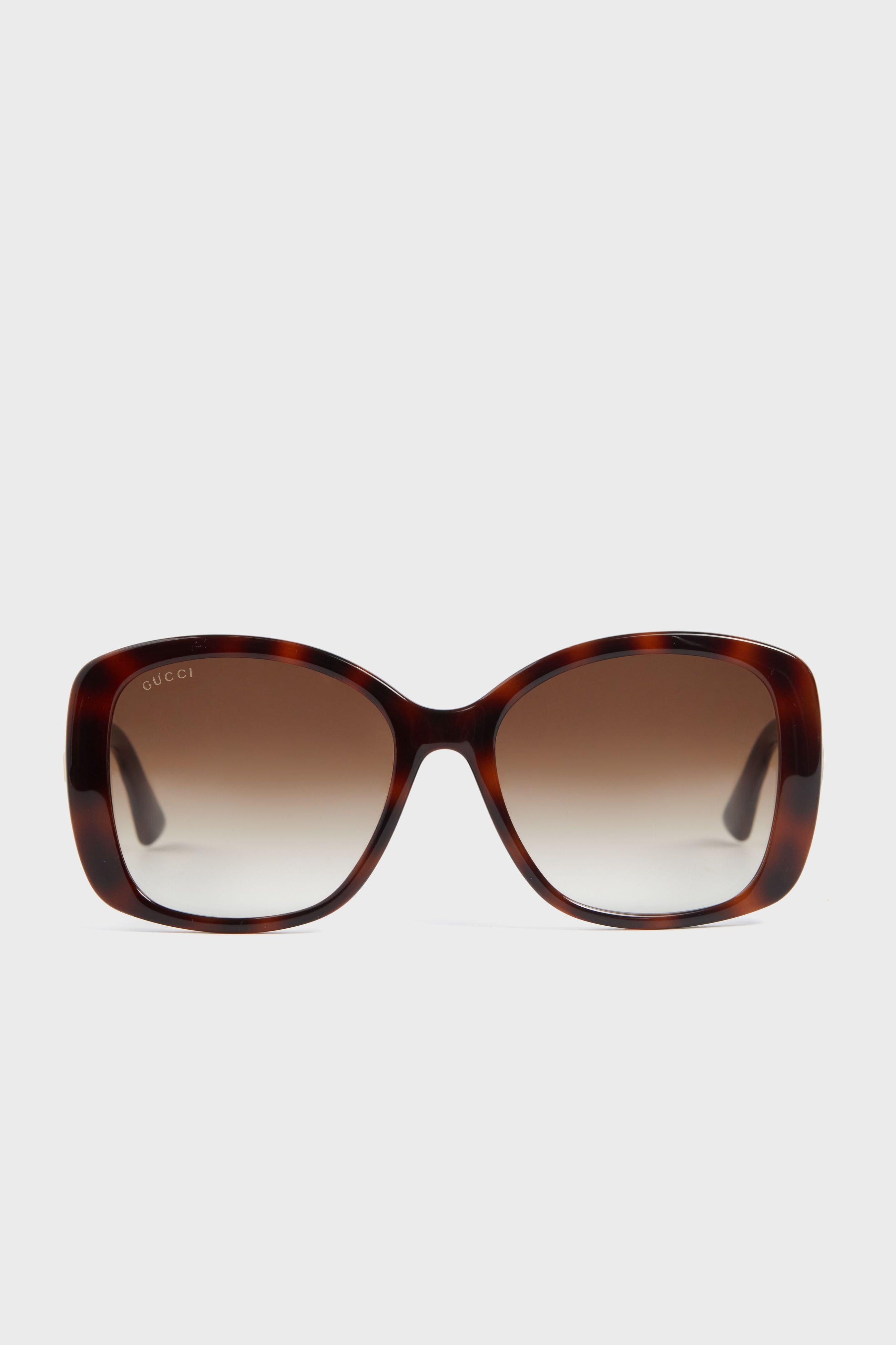 Gucci sunglasses feature oversized square tortoiseshell frames, gradient brown lenses, and the signature double G logo on the top left lens for a stylish look.
