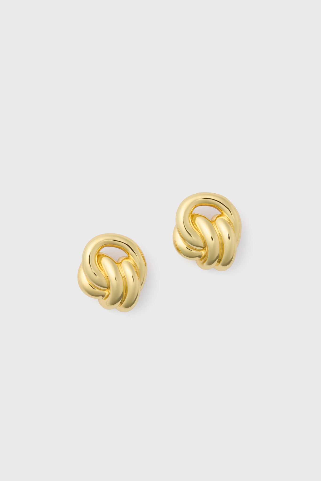 A pair of Petit Moments Miami Studs gold knot earrings, a chic accessory perfect for elevating any look.