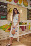 Young woman in a tropical market wearing Off White Gianna Flat Sandals, embodying classic, effortless style with a comfortable footbed, perfect for high-end, fun beach walks.