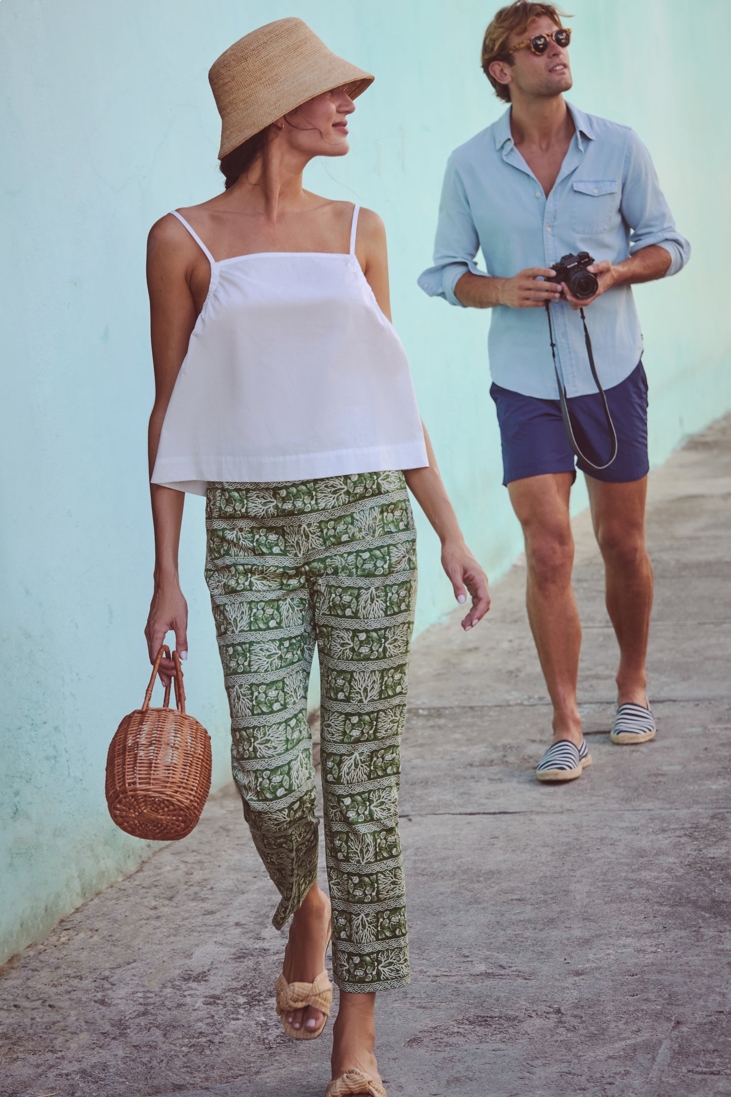 Woman in a classic White Cotton Madi Top with adjustable straps, showcasing an effortless, high-end look, styled with patterned pants, embodying fun and relaxed elegance.