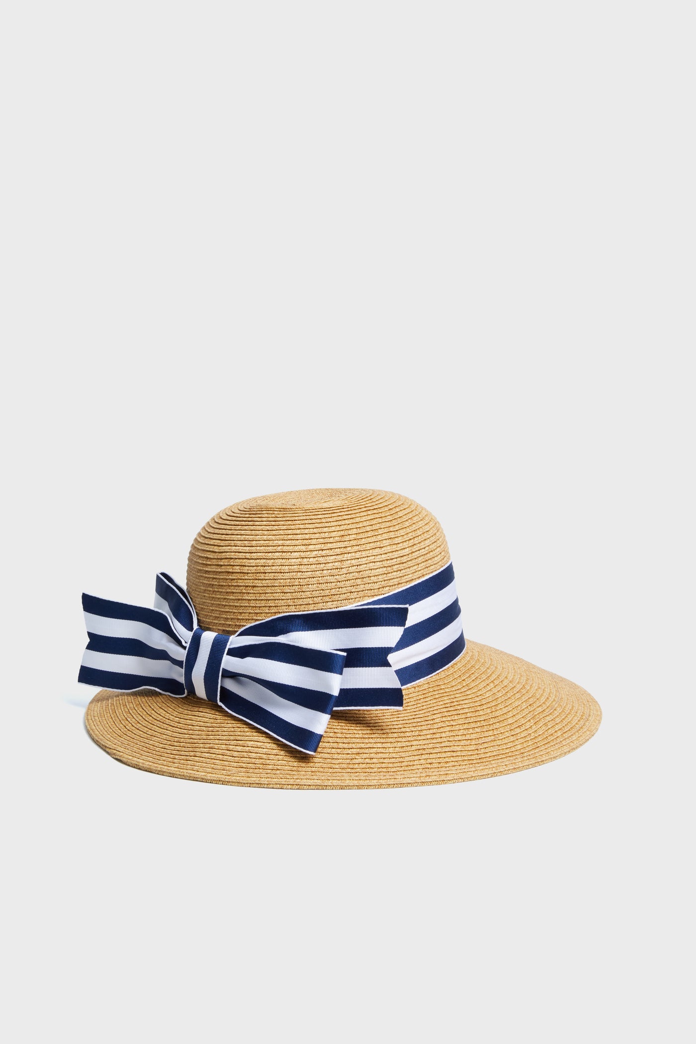 Toucan Hats wide-brimmed straw hat with a navy and white striped ribbon bow offers stylish sun protection. This packable accessory is perfect for your beach collection.