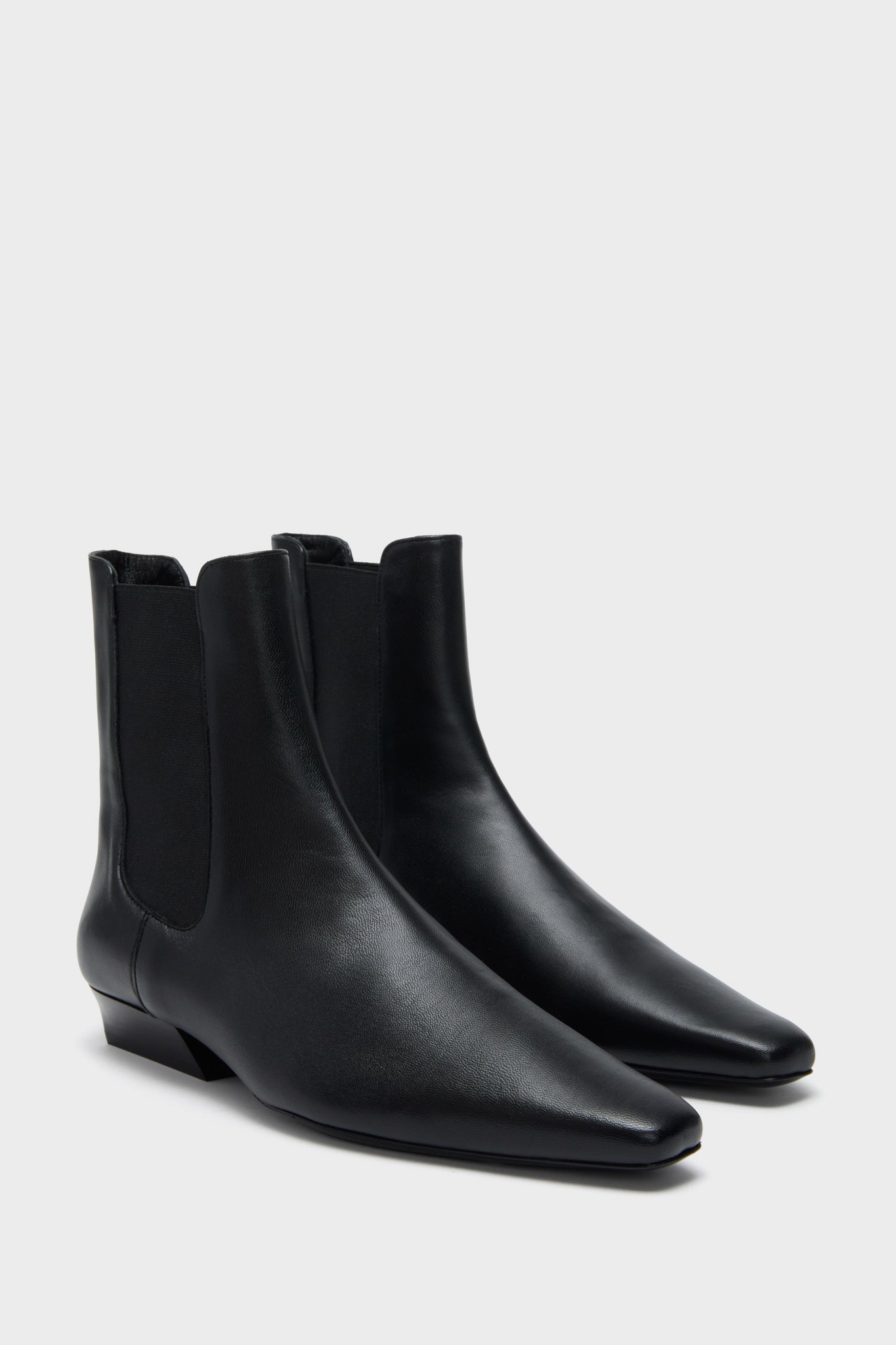 Black Wally Chelsea Boot: classic and high-end ankle-length leather boots with pointed toe, low stacked heel, and elastic panels; effortlessly cool and fun for daily wear.