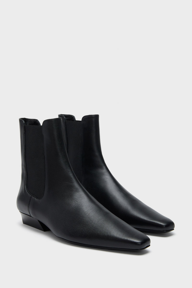 Black Wally Chelsea Boot: classic and high-end ankle-length leather boots with pointed toe, low stacked heel, and elastic panels; effortlessly cool and fun for daily wear.