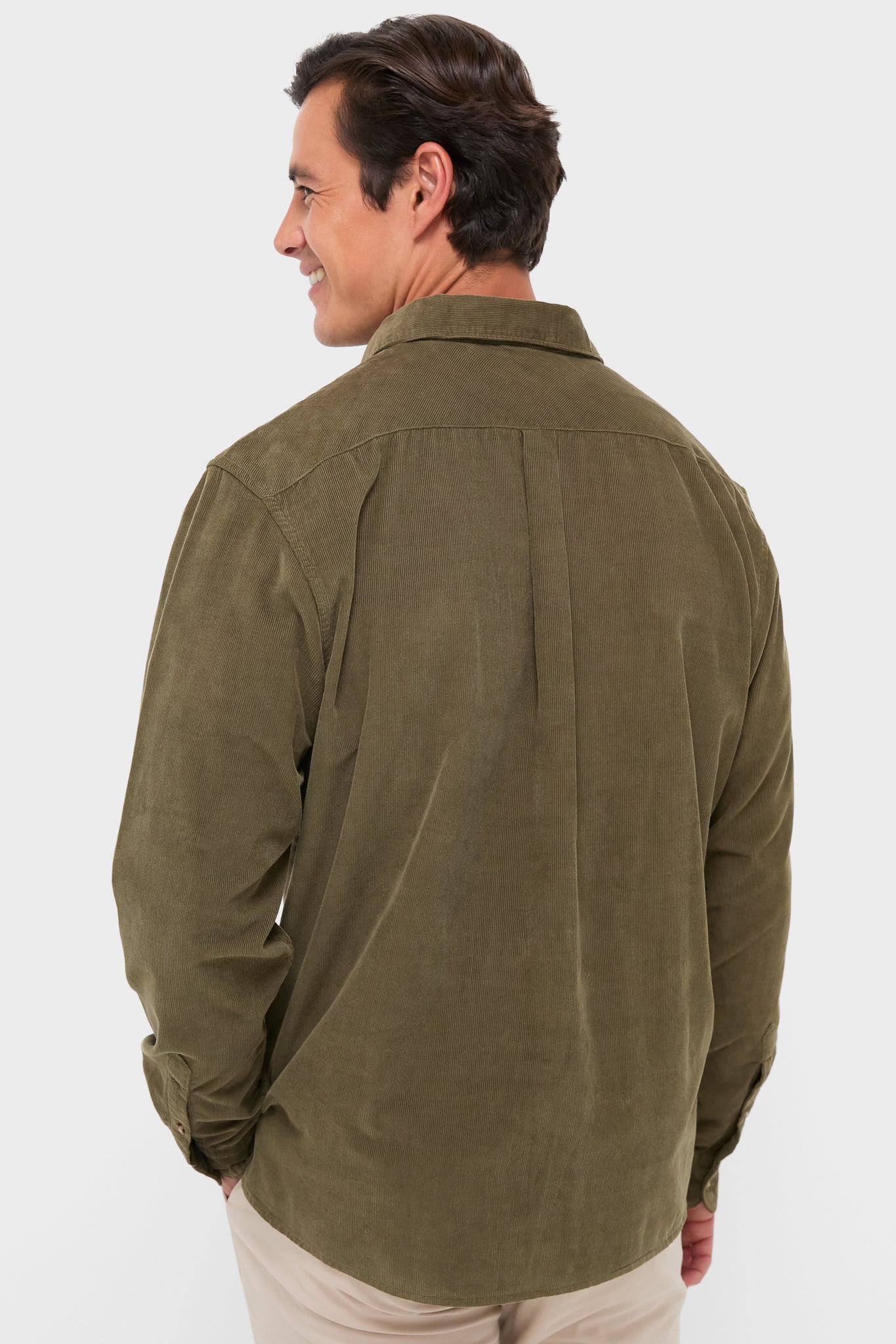 Man in olive Bramside Relaxed Cord Shirt and beige trousers, exuding classic and effortless style; a fun, high-end look perfect for fall.