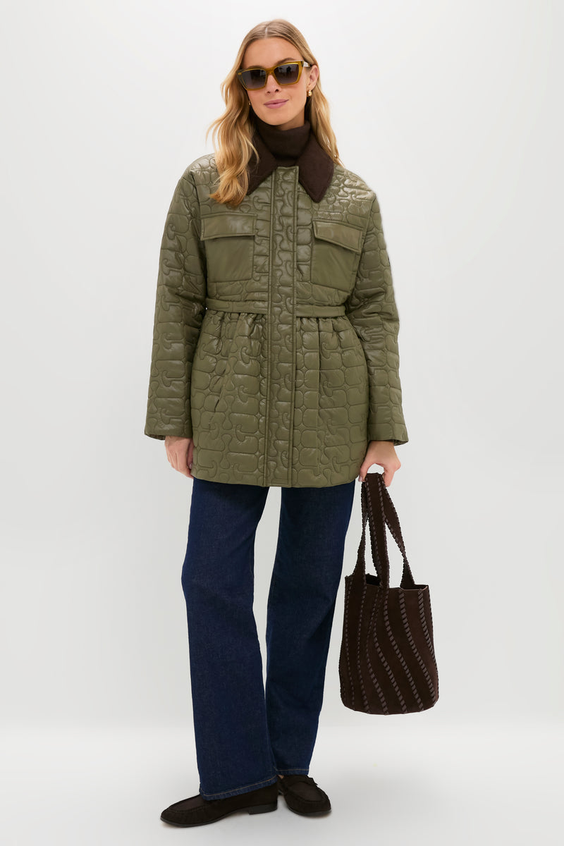 Person wearing Yves Saint Laurent Shiny Transparent Ocra Mica Sunglasses, embodying a classic, effortless style with a cat-eye frame, paired with a quilted jacket and jeans.