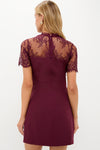 The Oxblood Lace Agatha Mini Dress showcases a classic, high-end design with sheer lace shoulders, embodying effortless elegance and fun sophistication for any event.