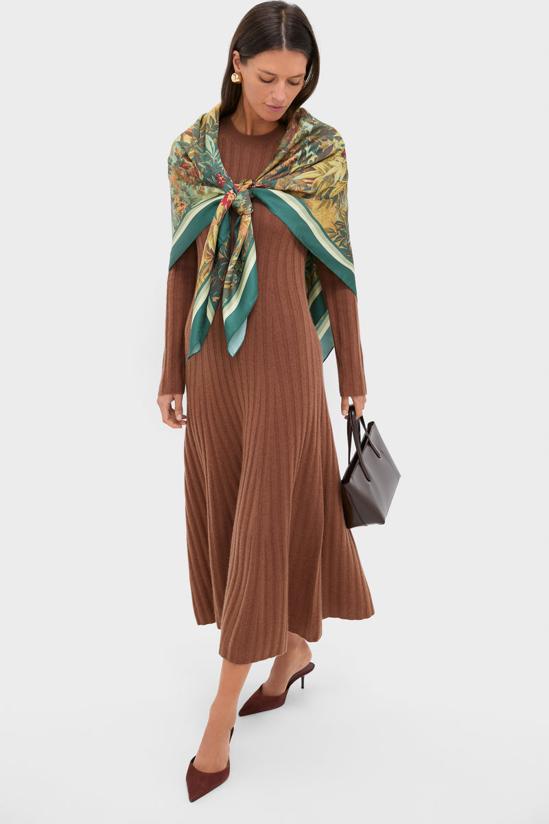 Model showcasing the Forest Toile Large Scarf in greens and golds, draped over a chocolate-brown maxi dress, embodying classic elegance and effortless, high-end style.