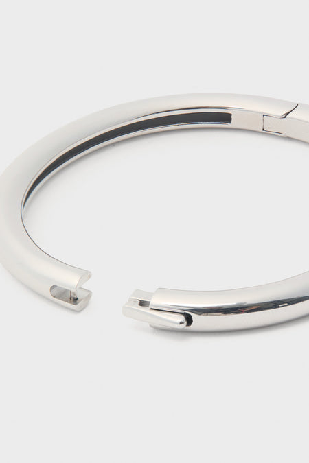 Silver Gia Bangle with high-polish finish and hinge push closure, showcasing its classic pin-and-slot mechanism. An effortless, high-end accessory for a fun, sophisticated look.