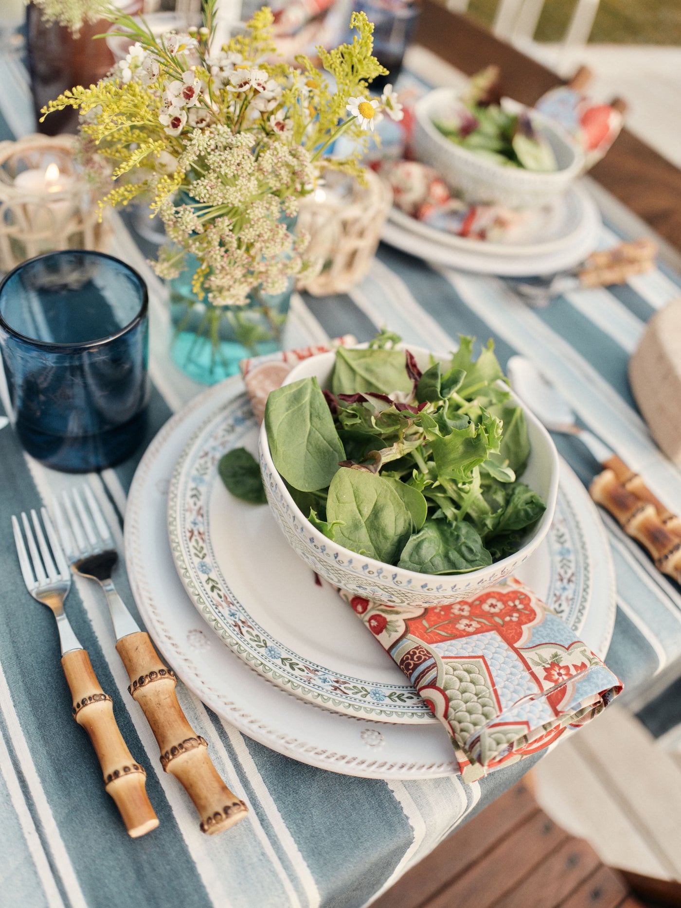 Table set for dinner with a salad and corn on serveware 