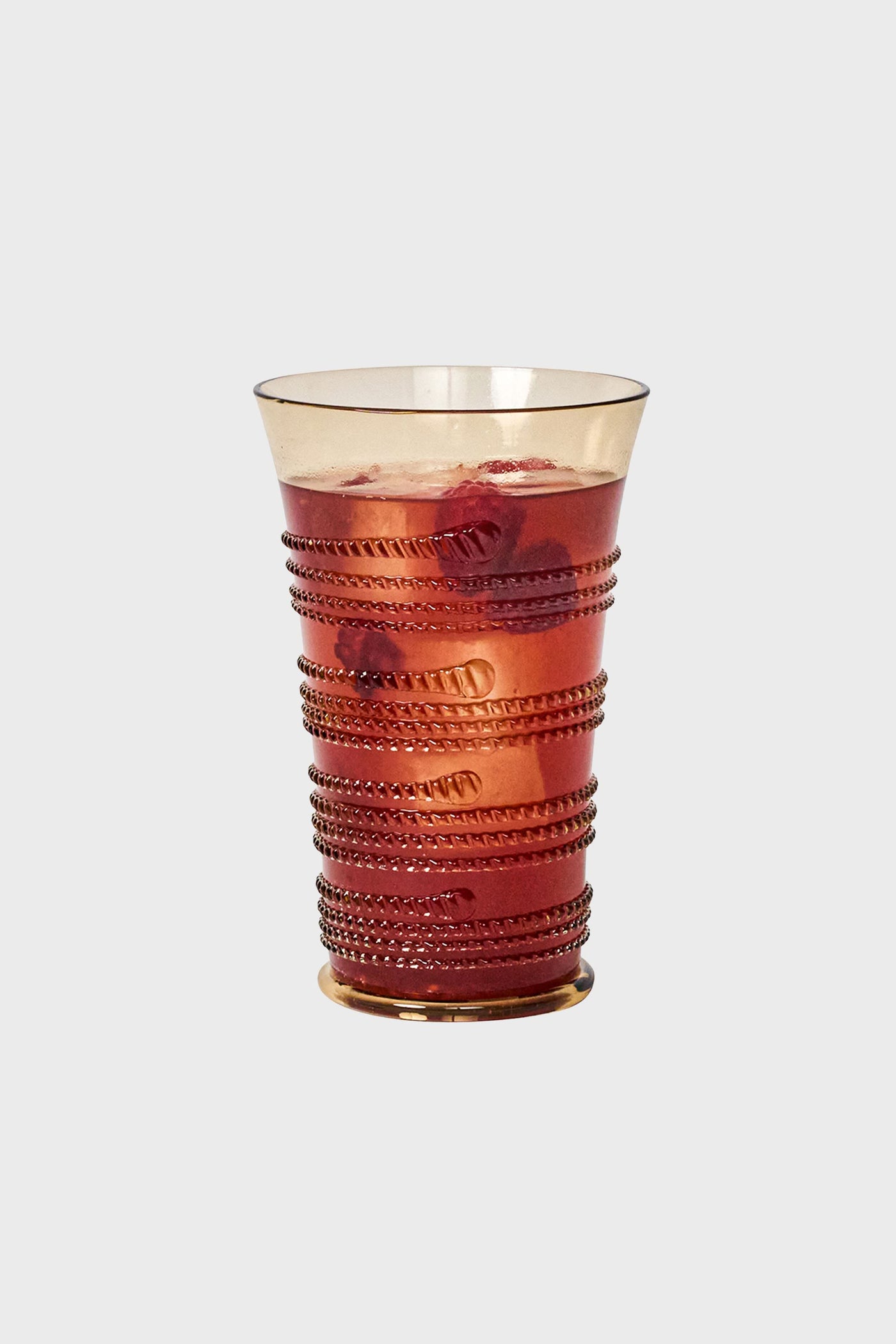 Amber Ella Large Tumbler in amber-glass with raised rope texture, filled with a vibrant red beverage, epitomizes classic, effortless elegance for fun, high-end dining experiences.