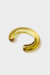Apple Ridge Cuff, a classic crescent-shaped amber glass bangle, effortlessly combines fun and high-end style, perfect for layering or wearing solo.