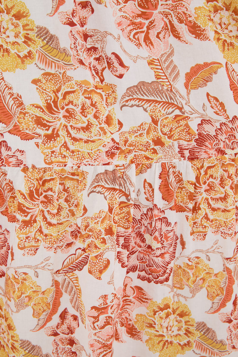 Hyacinth House fabric with a vibrant floral pattern in orange, yellow, and red on a white background—ideal for sewing a flowy maxi dress.