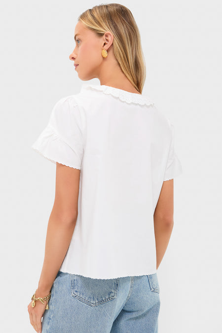 Vintage White Ezra Blouse with scalloped eyelet collar and sleeves, styled effortlessly with blue jeans and gold accessories, embodying classic, fun, high-end charm.