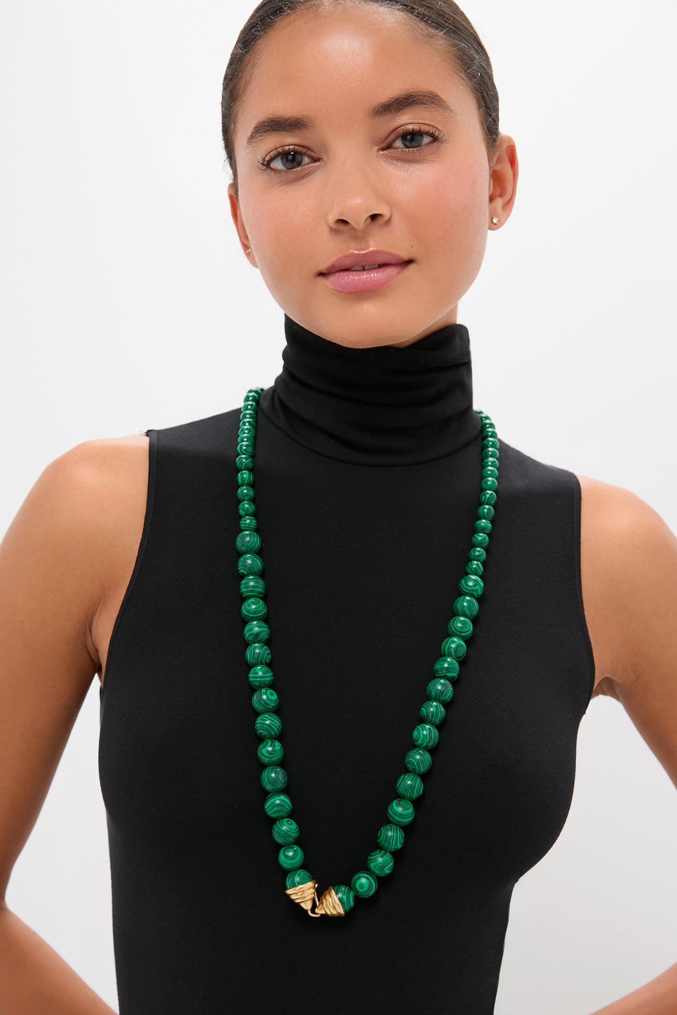 Model wearing the classic Malachite Double Strand Celine Necklace, featuring malachite beads and gold-tone accents, offering an effortless, high-end style with versatile, fun layering options.