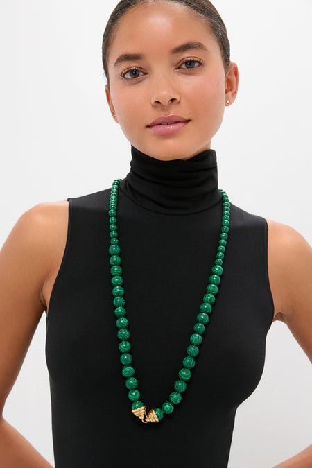 Model wearing the classic Malachite Double Strand Celine Necklace, featuring malachite beads and gold-tone accents, offering an effortless, high-end style with versatile, fun layering options.