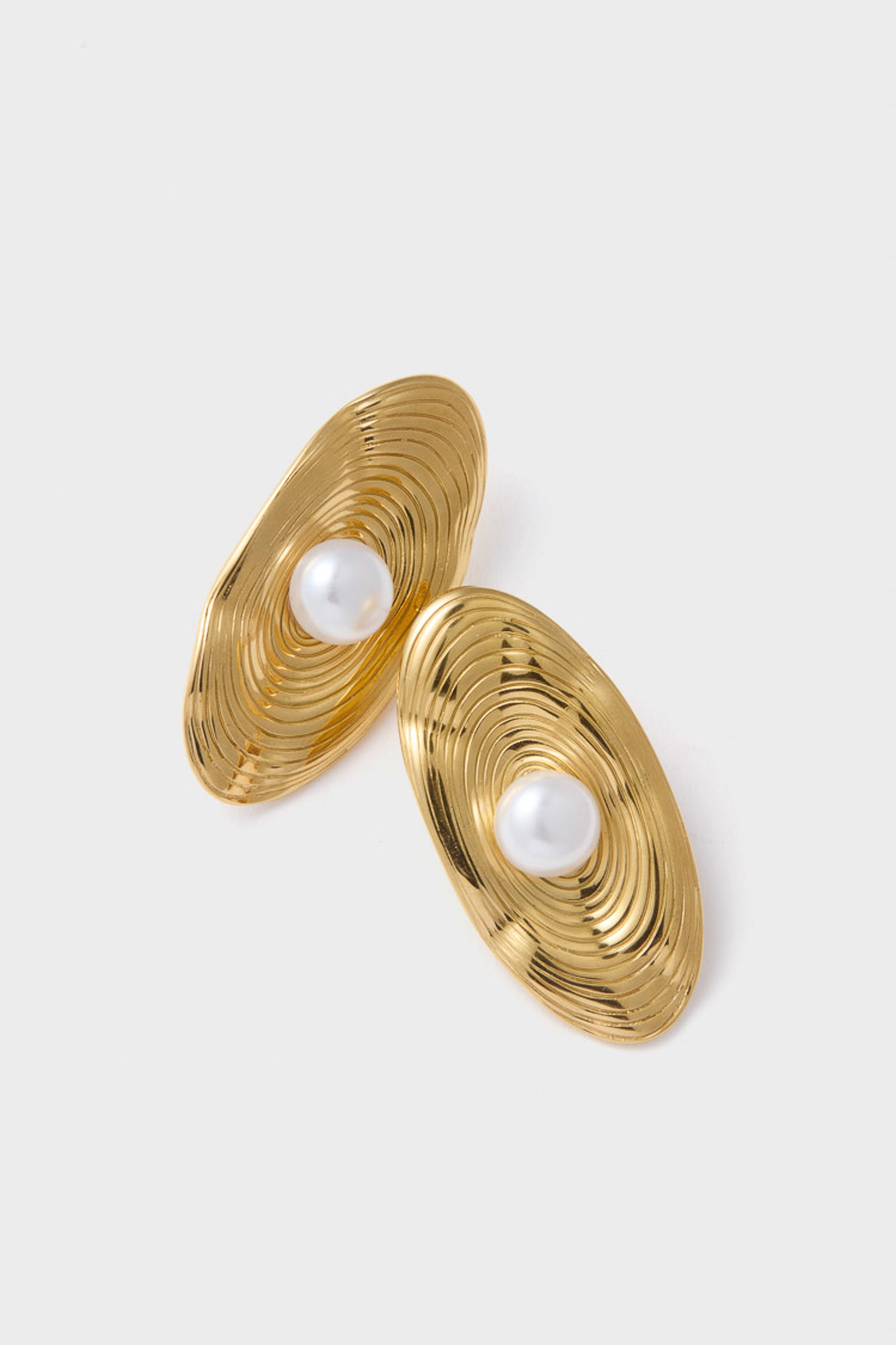Gold Trumbull Earrings with concentric rippled gold-tone grooves and centered faux-pearl, blending classic elegance with a modern twist for an effortless, fun, high-end look.