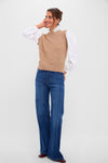 Woman models the Desert Melange Ella Sweater Blouse, a classic, effortless blend of a camel-brown knit vest and chic white blouse, with high-waisted jeans.