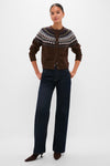 Woman models the classic Chestnut Amina Fairisle Sweater, paired with high-waisted jeans and brown suede boots, epitomizing an effortless, fun, and high-end style.