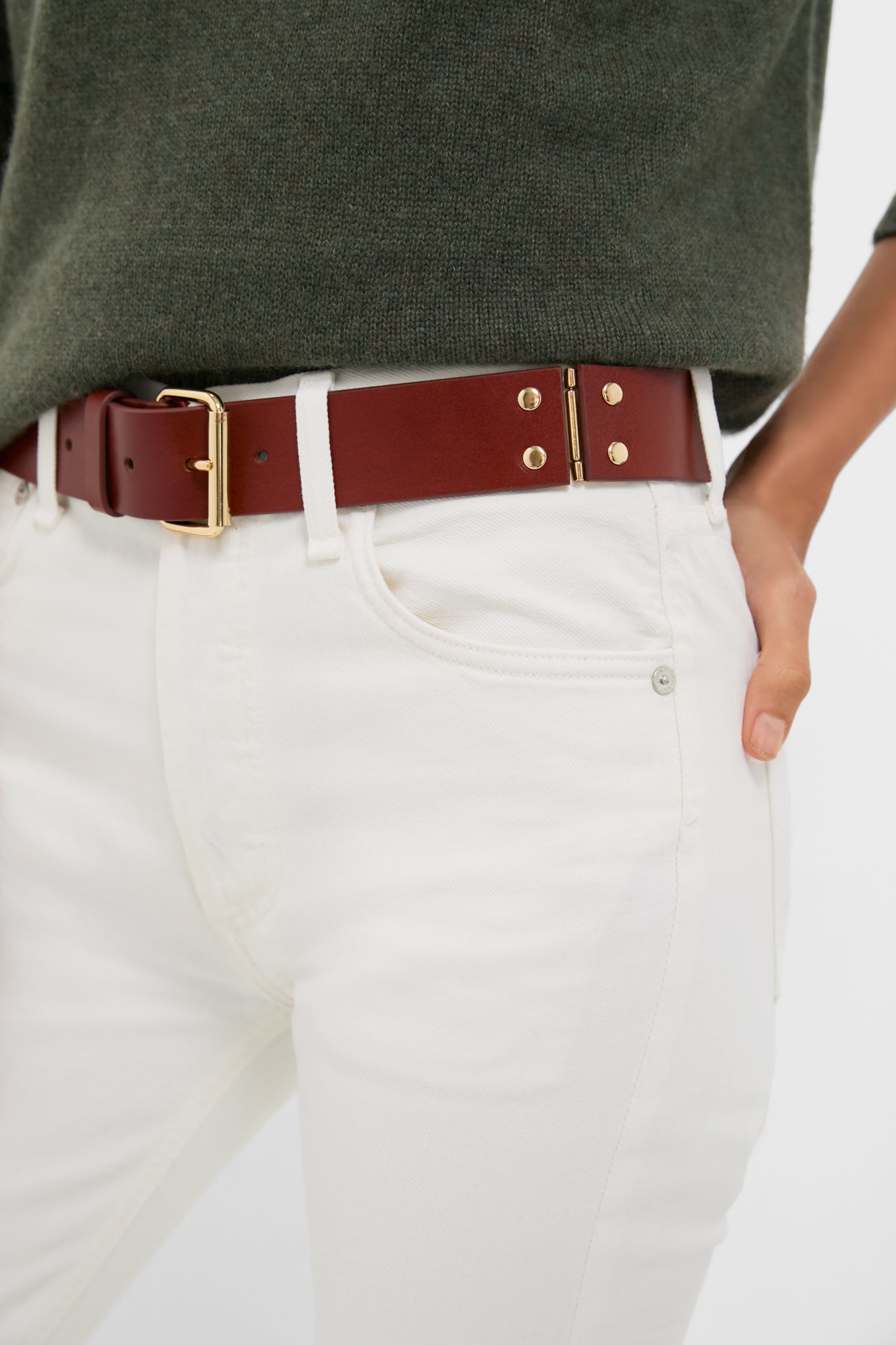 Close-up of the Dark Tan Hinge Belt, showcasing its classic gold-tone hardware and unique hinge detail, effortlessly elevating the off-white jeans for a high-end, fun look.