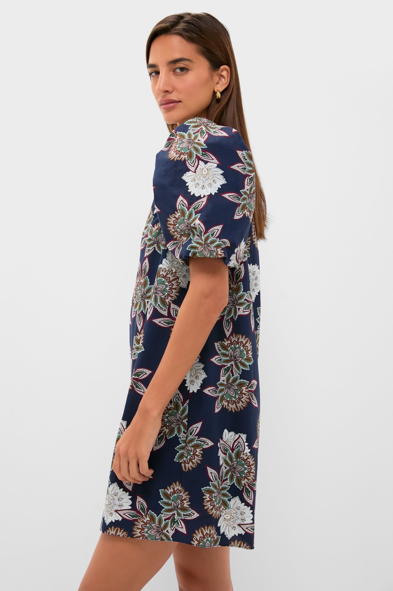 Young woman models the Navy Floral Mimi Mini Dress featuring puff sleeves and a ruffle collar, exuding classic, effortless style with a fun, high-end floral pattern.