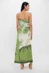 Back view of a person in the Ireland Green Wess Midi Dress, featuring a classic strapless design with bold leaf motifs and a sleek side slit.