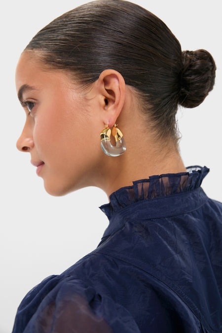 Young woman wearing Aqua Organic Hoops, featuring gold-plated brass and acrylic in a modern, sculptural design; a classic, effortless accessory adding fun and high-end style.