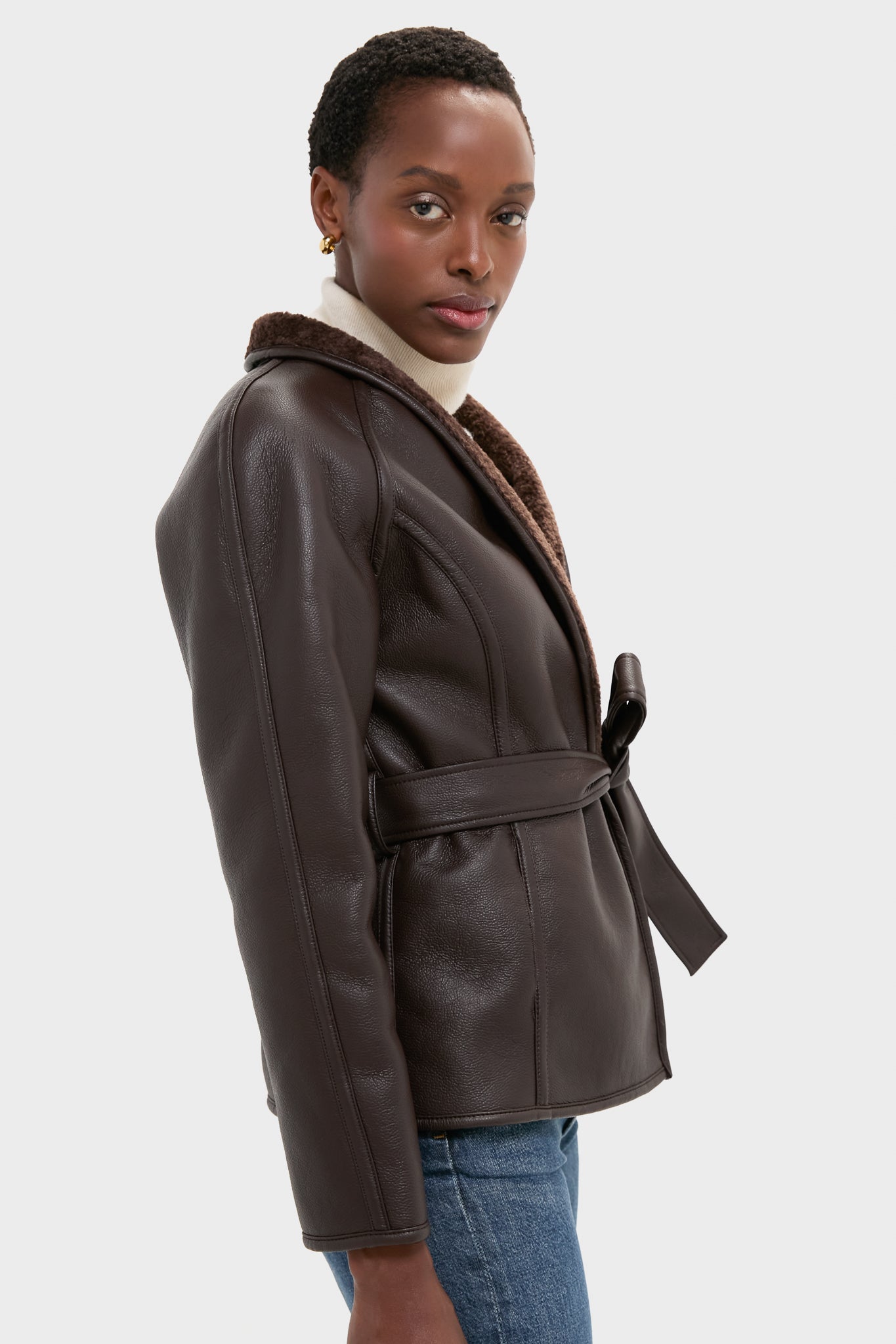 Reversible Marron Fur Coat: A classic, high-end faux leather jacket with a self-tie belt, shearling lining, effortlessly styled with a sweater and jeans for a fun, sophisticated look.