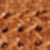 A close-up, softly blurred image of a woven fabric featuring an intricate brown and tan pattern.