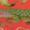 A whole pineapple with green leaves sits on a red surface, surrounded by fresh kiwi slices and assorted tropical fruits.