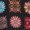 Colorful geometric quilt blocks with floral patterns are arranged in a grid. Each block features a unique design and vibrant color palette.