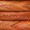 Close-up view of four freshly baked baguettes with golden-brown crusts arranged in parallel rows.
