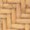 Close-up of a wooden surface, showcasing a striking herringbone pattern crafted from rectangular pieces of light oak.