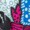 Close-up of colorful patterned textiles, including red with black shapes, blue with white dots, and white with teal shapes.