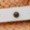 A close-up image of a metal screw fastened into a white surface, with a blurred brown textured detail behind it.