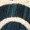 A close-up of a dark, curved, and textured surface with a beige or light-colored border and intricate details.