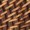 Close-up of a woven wicker pattern with diagonal, interlacing strips in natural, rustic shades of brown.