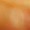 Blurred close-up image with warm orange and yellow tones, suggesting an abstract surface or painterly composition.