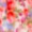 Blurry image with a mix of red, pink, purple, and white hues swirling together in an abstract pattern.
