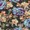 A close-up view of a dense arrangement of vibrant artificial roses and flowers, primarily in blue, beige, and purple tones, creates a striking floral display.